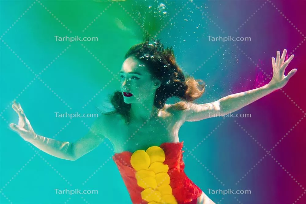 پرتره سوررئالیستی از یک زن جوان و جذاب در زیر آب با حبابهای هوا و رنگهای زنده در استخر شنا
