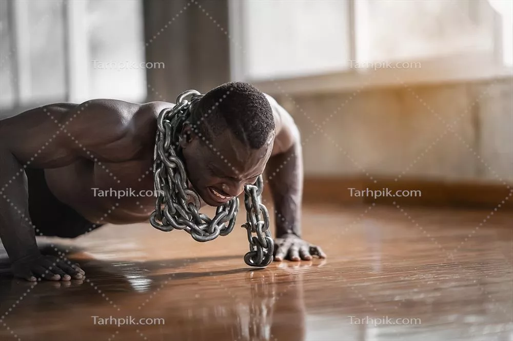 مرد افریقایی در حال استفاده از زنجیر برای انجام تمرین Push-up در باشگاه