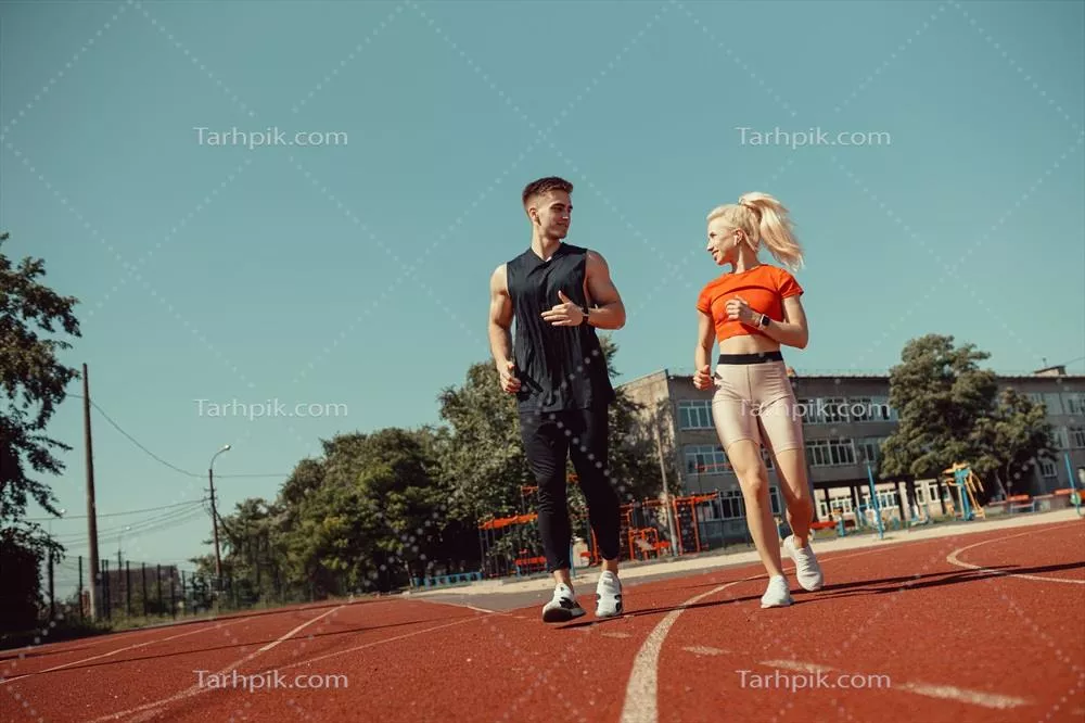 دویدن یک زوج جوان ورزشکار در استادیوم بر روی پیست دویدن
