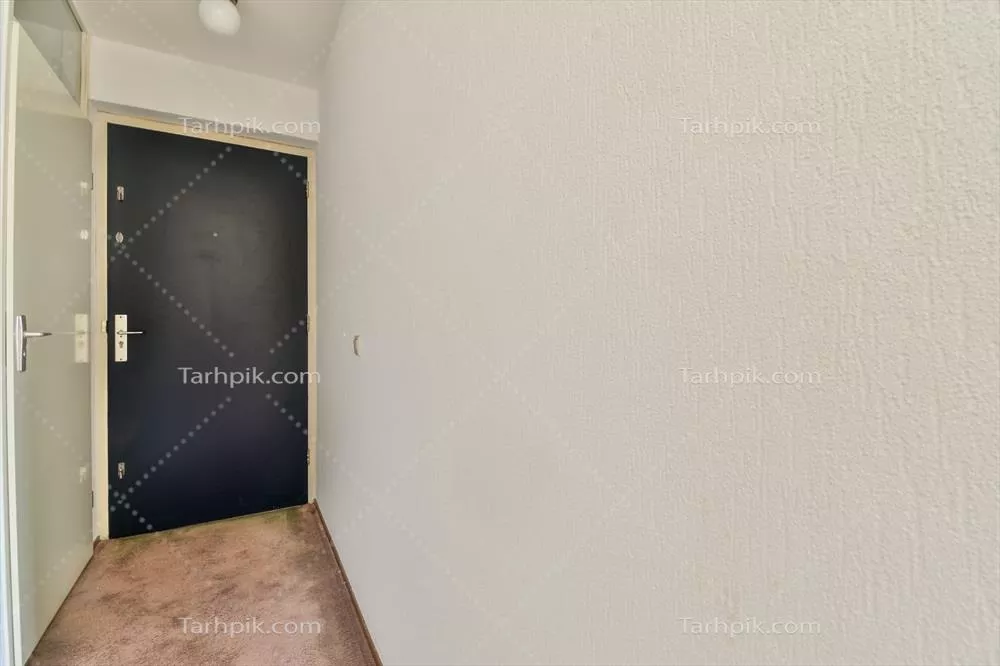 یک راهرو با درب مشکی و دیوار سفید به شکل مدرن و مینیمالیستی