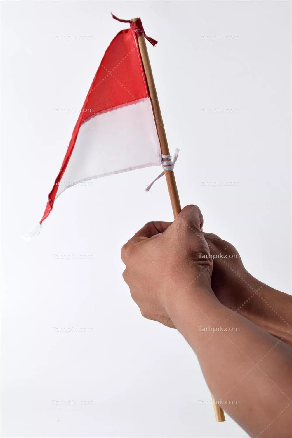 بالا بردن پرچم قرمز و سفید اندونزی توسط یک مرد