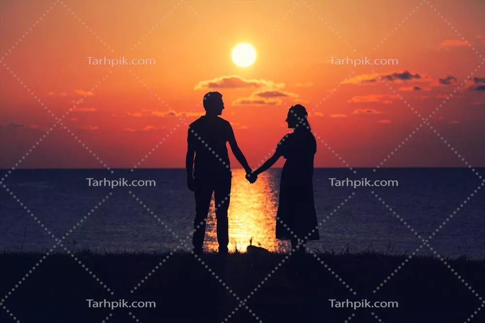 دو نفر در غروب آفتاب دست در دست یکدیگر