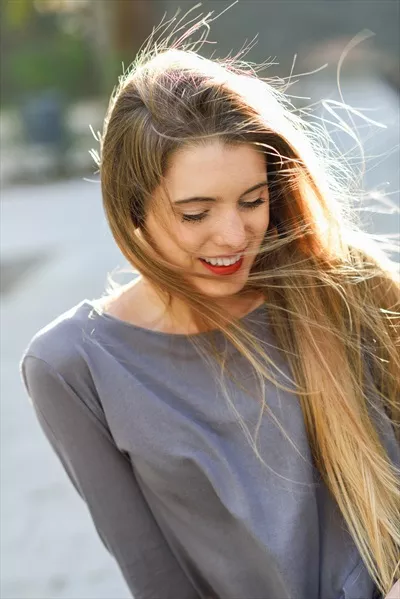 دختر خوشحال بلوند در پسزمینه شهری شلوغ و زنده