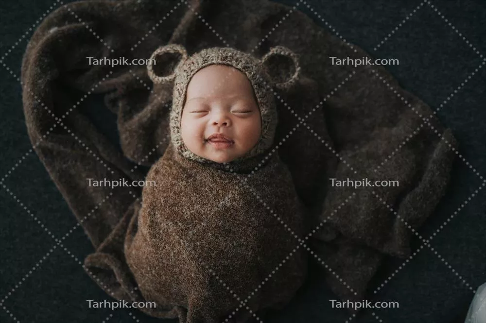 نوزاد خوشحال درون یک پیله نرم و راحت همراه با آرامش
