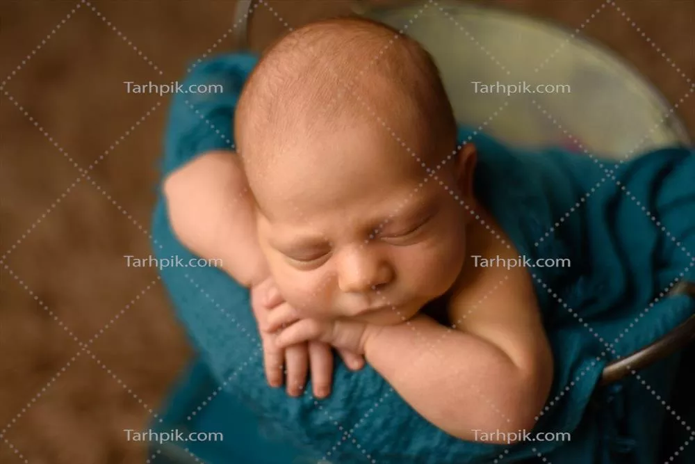 نوزاد زیبای تازه متولد شده که دستانش را بر روی صورتش rested