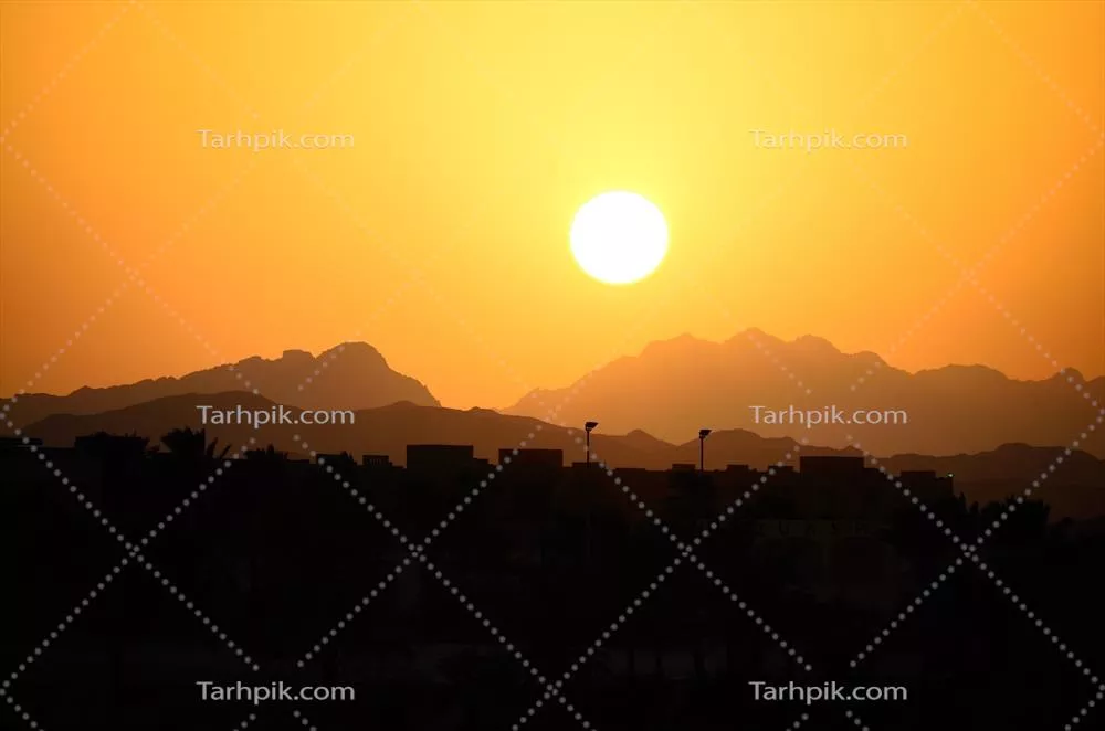 غروب آفتاب برفراز کوه‌ها و خانه‌ها در دل طبیعت