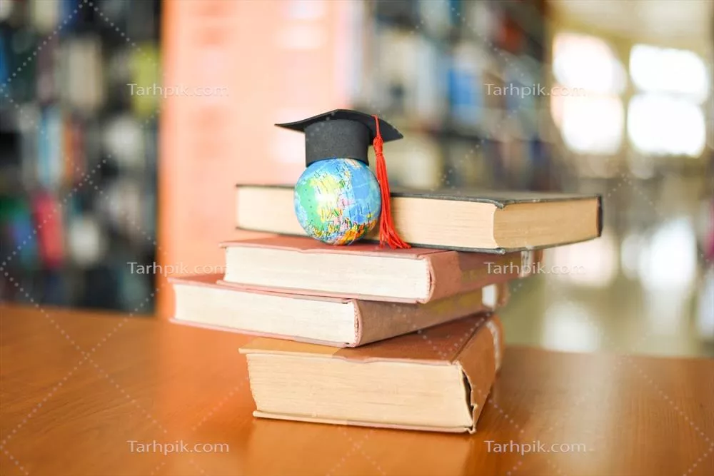 مجموعه کتابها بر روی میز در کتابخانه با کلاه فارغالتحصیلی و مدل کره زمین