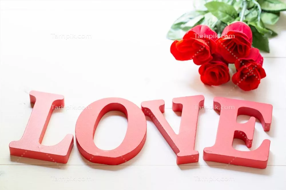 هدیه عاشقانه با گل رز قرمز و کلمه عشق روی میز چوبی برای روز ولنتاین