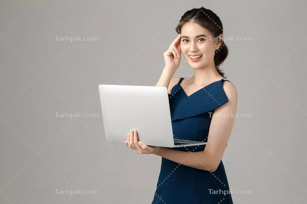 زنی جوان و پرانرژی از آسیا با لپ تاپ در دست و افکار درگیری در پس‌زمینه خاکستری