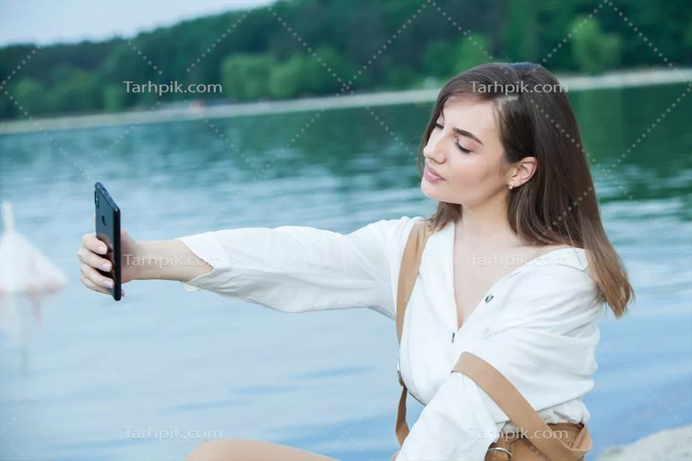 دختر خوشحال در فضای باز در حال پیام دادن با موبایل خود