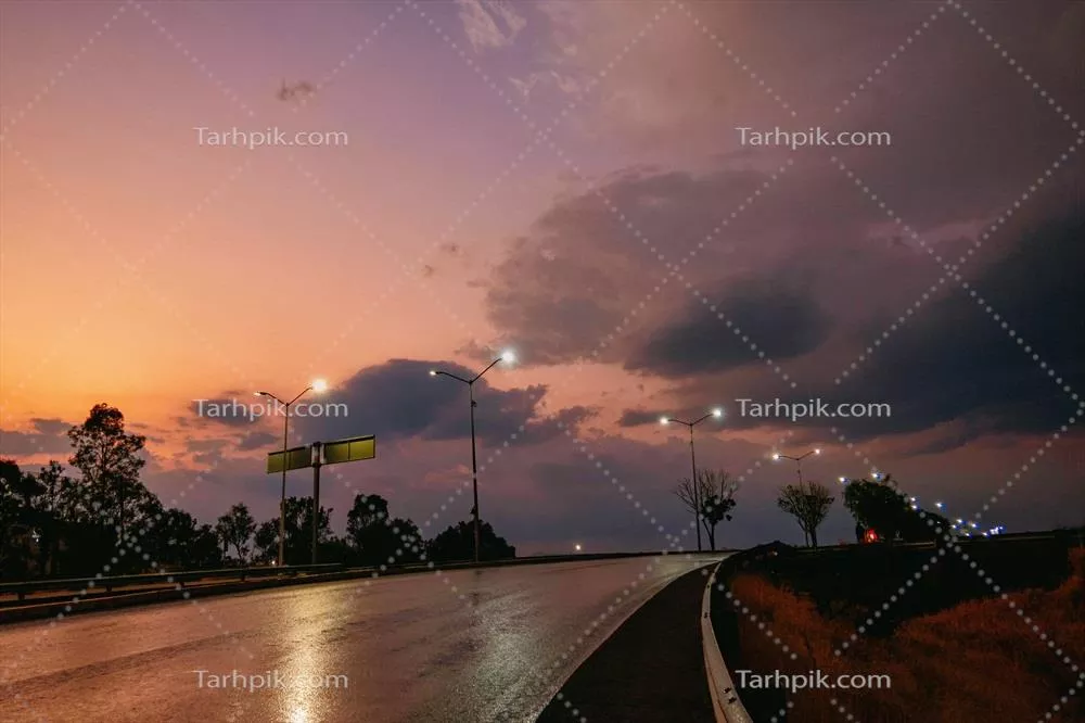 جادهای روشنشده با چراغها در غروب زیبای آفتاب