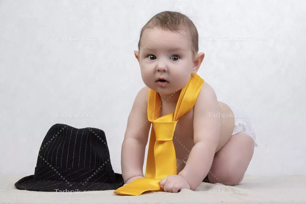 کودک شاد با کلاه و کروات قدیمی در پس‌زمینه سفید، نوزاد شش ماهه با لباس‌های شیک و خنده‌دار