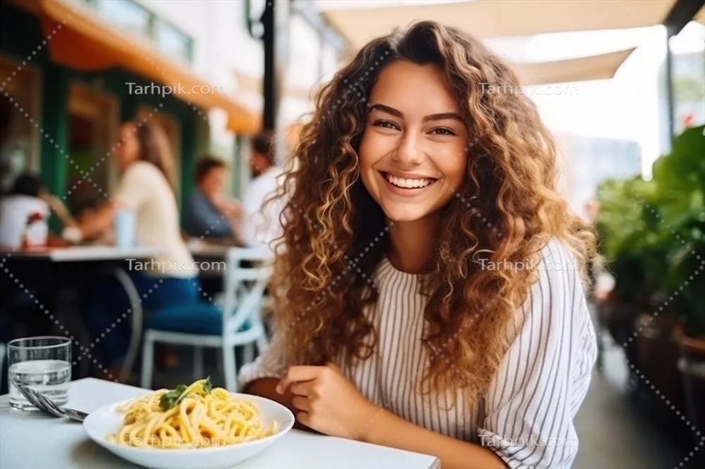 دختر در کافی شاپ خیابانی به غذا خوردن پاستا مشغول است