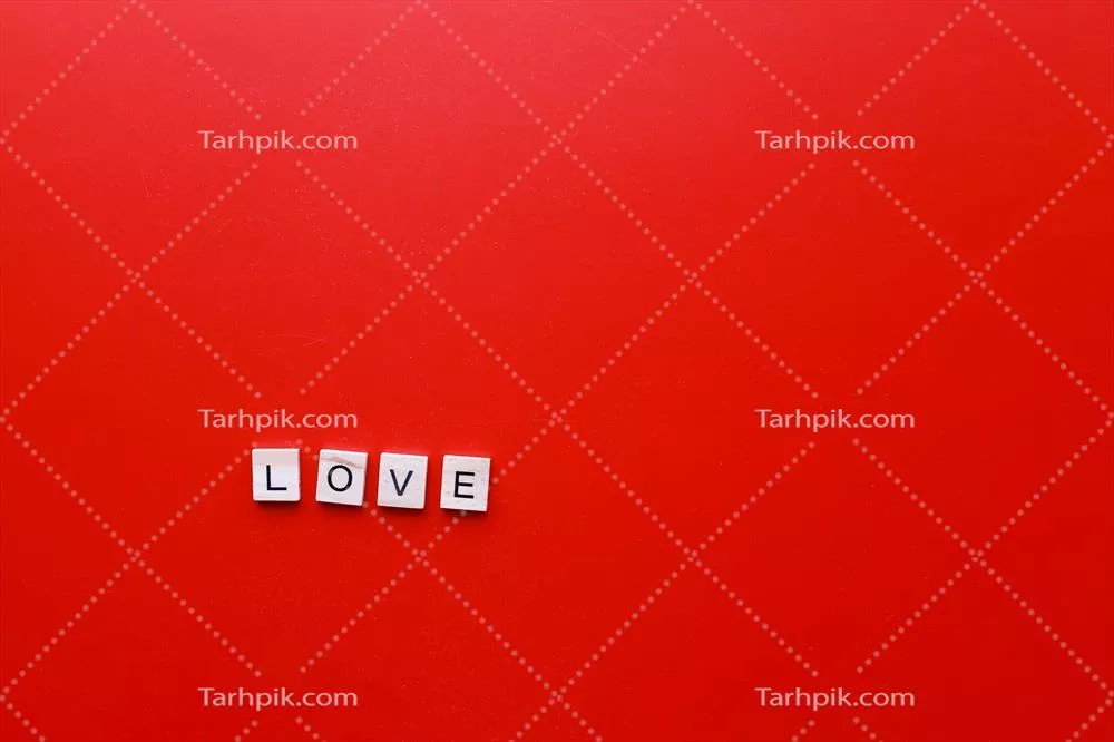 کلمه عشق با حروف چوبی بر روی پسزمینه قرمز برای روز ولنتاین