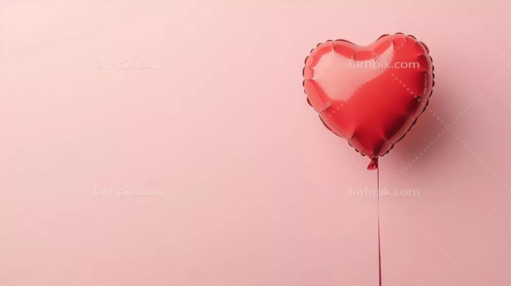 بادکنک قلبی قرمز رنگ در پس زمینه ملایم صورتی برای جشنها و مناسبتهای عاشقانه