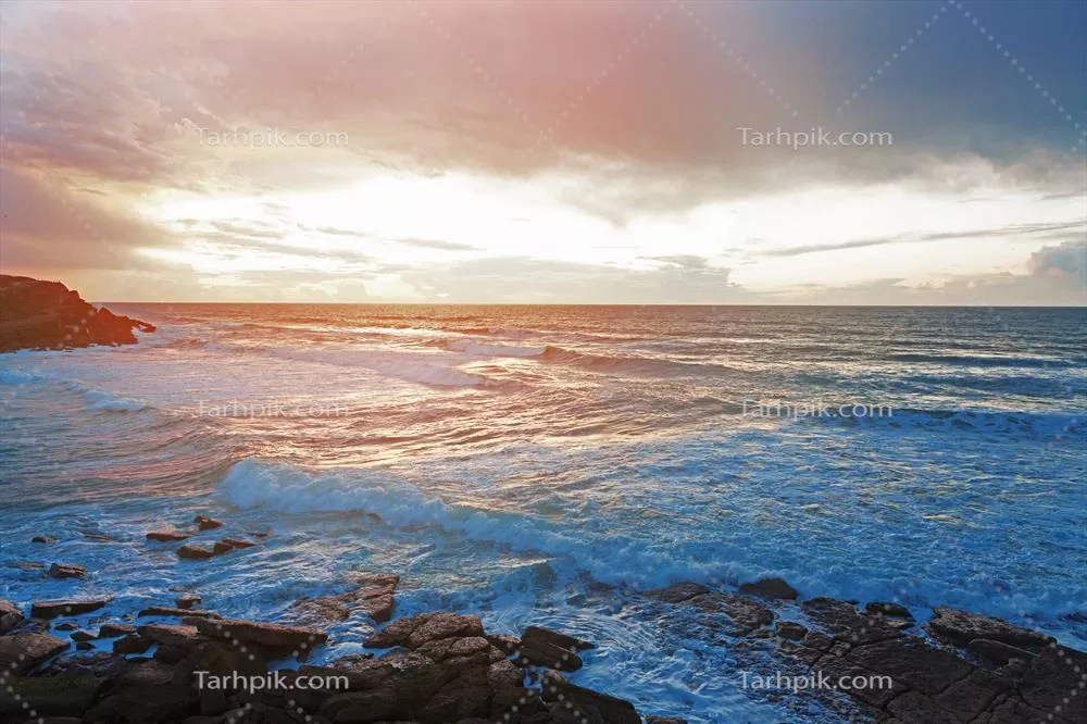 چشمانداز زیبا با غروب خورشید و امواج اقیانوس در افق