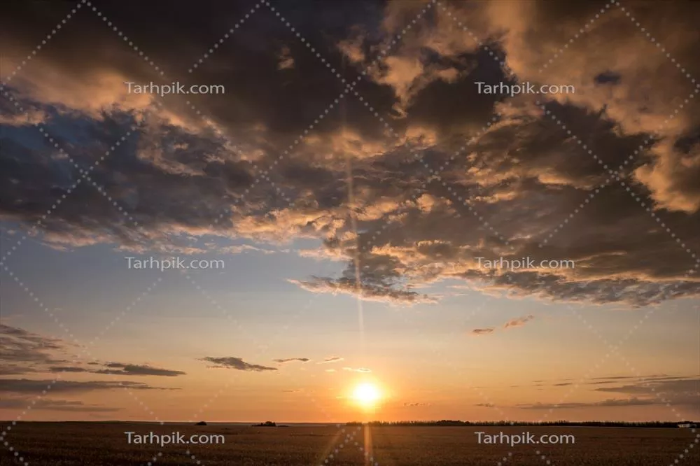 پسزمینه آسمان آبی و قرمز با ابرهای پفی و فرخورده در حال غروب آفتاب و هوای خوب و بادی