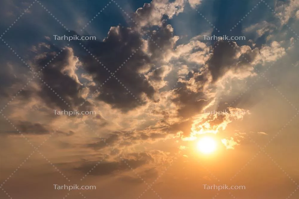 زمینه آسمان آبی با ابرهای پفکی و فرشی غروب و خورشید در حال غروب