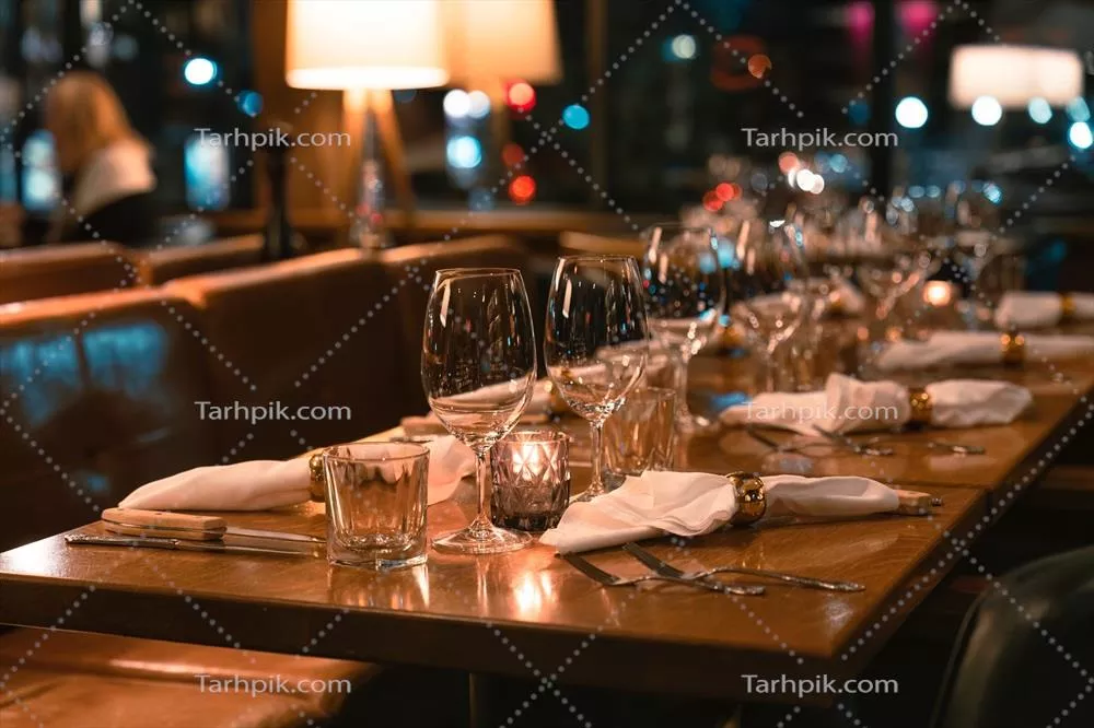 چیدمان میز طولانی رستوران با کارد و چنگال و لیوان شراب برای پذیرایی