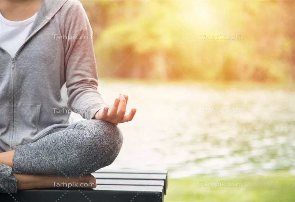 زن جوان یوگا در حال مدیتیشن و آرامش در دل طبیعت