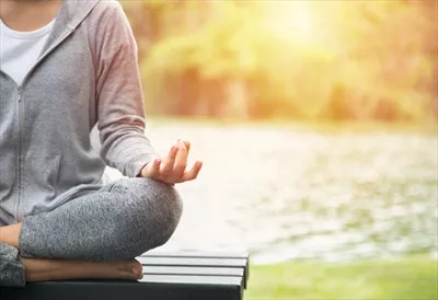 زن جوان یوگا در حال مدیتیشن و آرامش در دل طبیعت