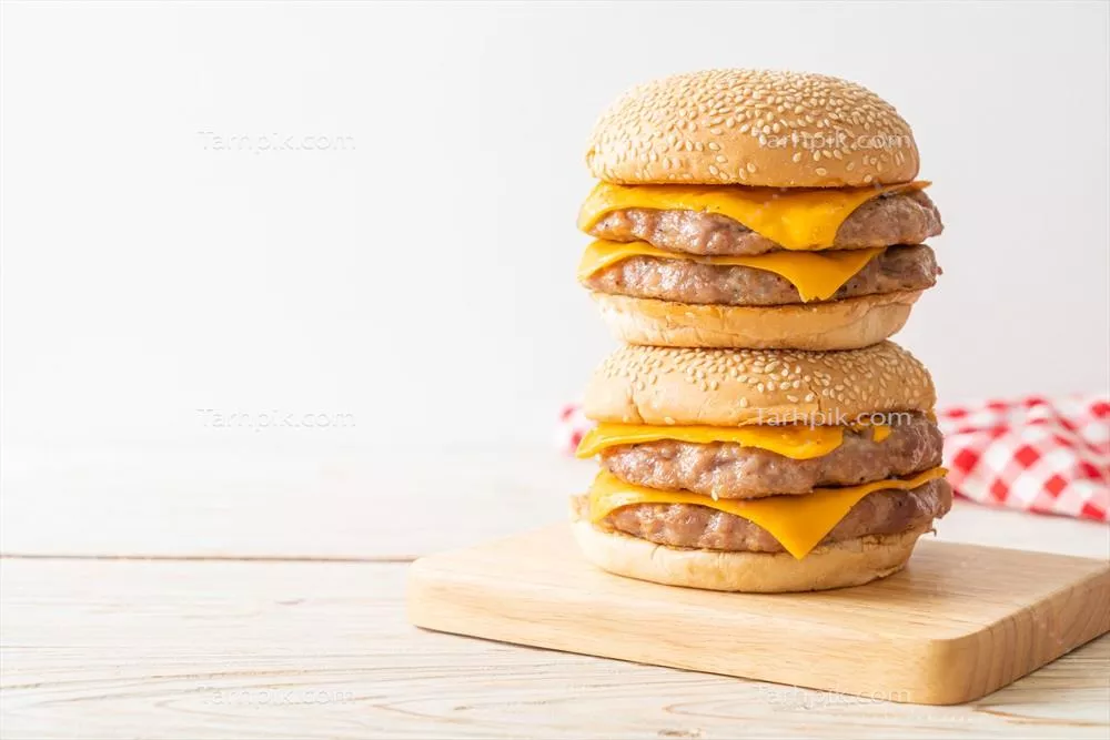 همبرگر خوک با پنیر بر روی تخته چوبی ولذیذ و خوشمزه