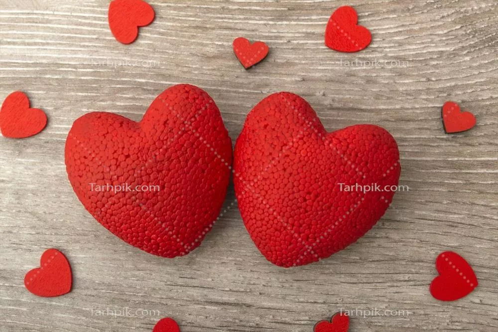 تصویری نزدیک از دو قلب روی یک پسزمینه چوبی برای مفهوم عشق با فضای خالی