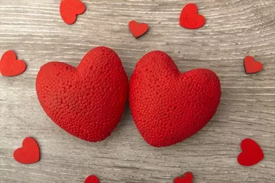 تصویری نزدیک از دو قلب روی یک پسزمینه چوبی برای مفهوم عشق با فضای خالی