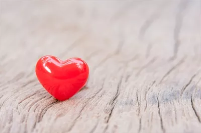 زمینه روز ولنتاین با قلبهای قرمز روی چوبهای تختهای و فضای خالی برای متن