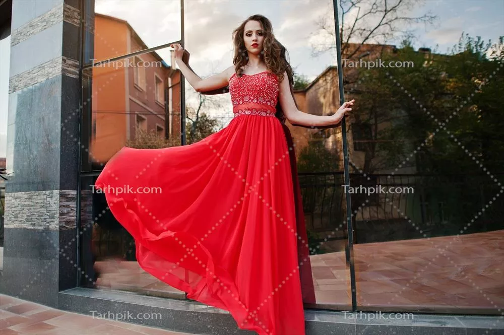 پرتره ای از دختری شیک در لباس شب قرمز در پسزمینه آینهای ساختمان مدرن