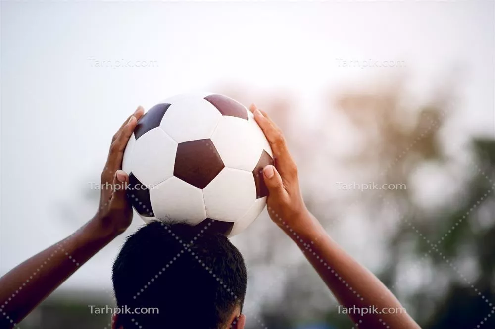 تصویر برش‌خورده از بازیکنان ورزشی که توپ را می‌گیرند در زمین فوتبال