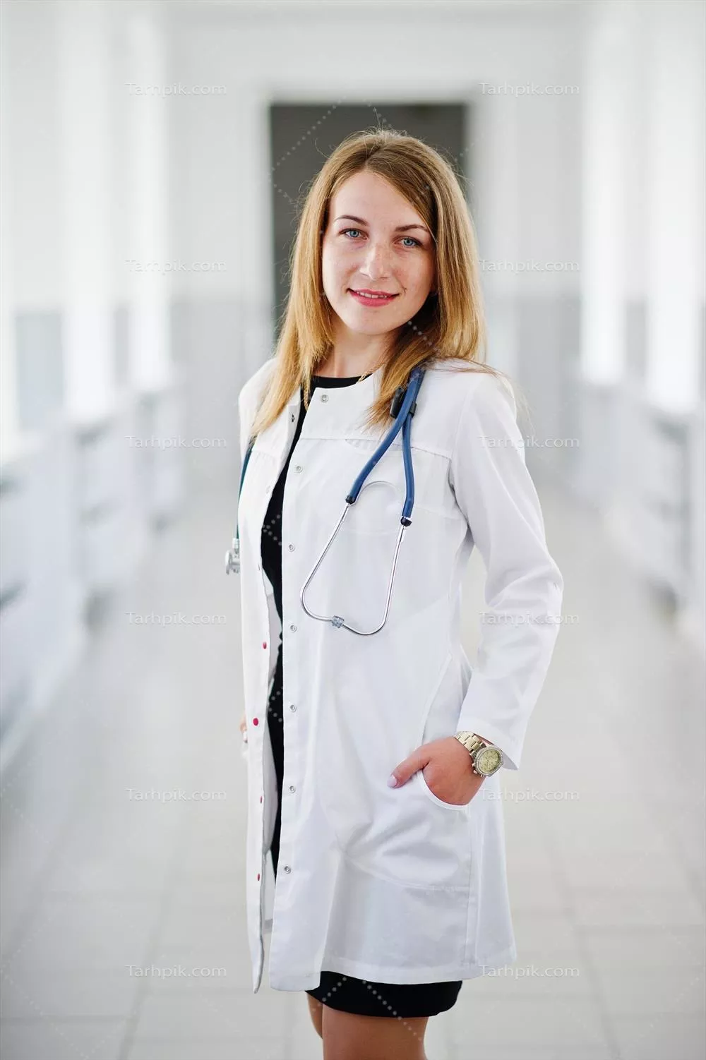 پرتره ای زیبا از یک پزشک جوان و جذاب در کت سفید با گوشی پزشکی در بیمارستان