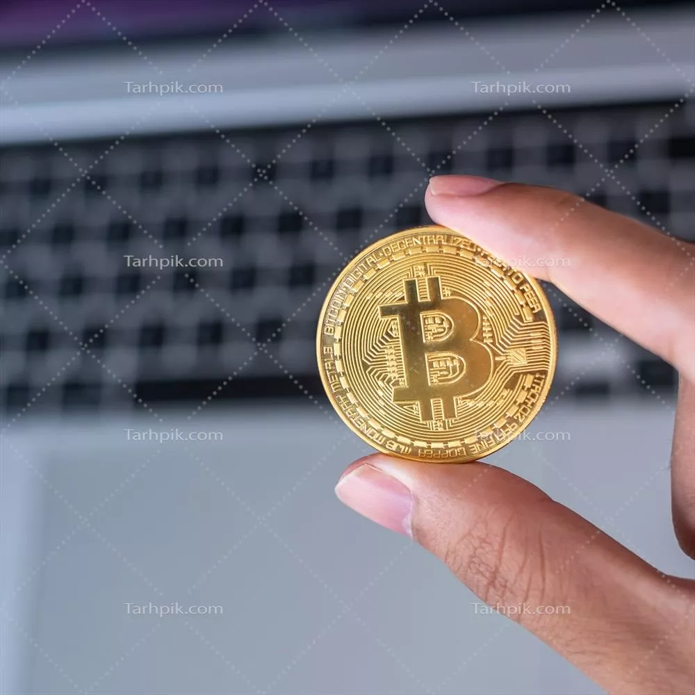 کسب و کار: مردی با دست خود بیت کوین طلایی بر روی کیبورد لپتاپ به نمایندگی از پول دیجیتال