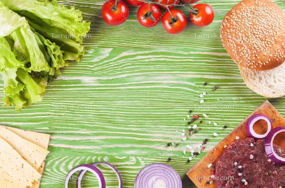 مواد اولیه برای تهیه همبرگر بر روی پسزمینه چوبی سبز