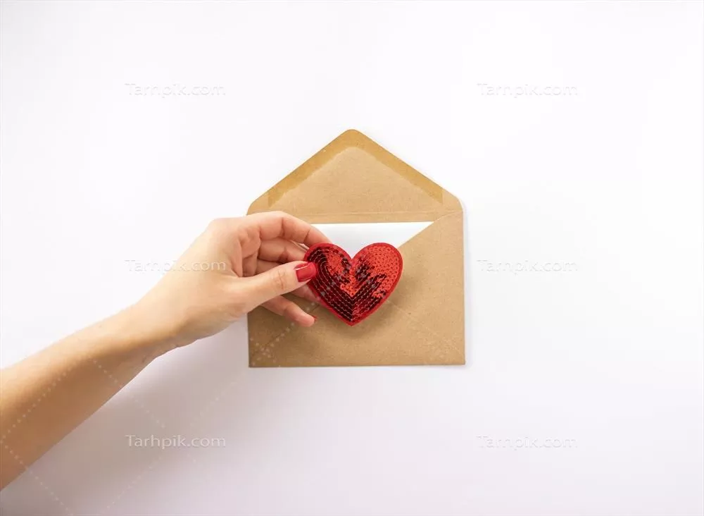 زنی که قلب قرمزی را در دست دارد و آن را برای روز ولنتاین در یک پاکت ارسال می‌کند
