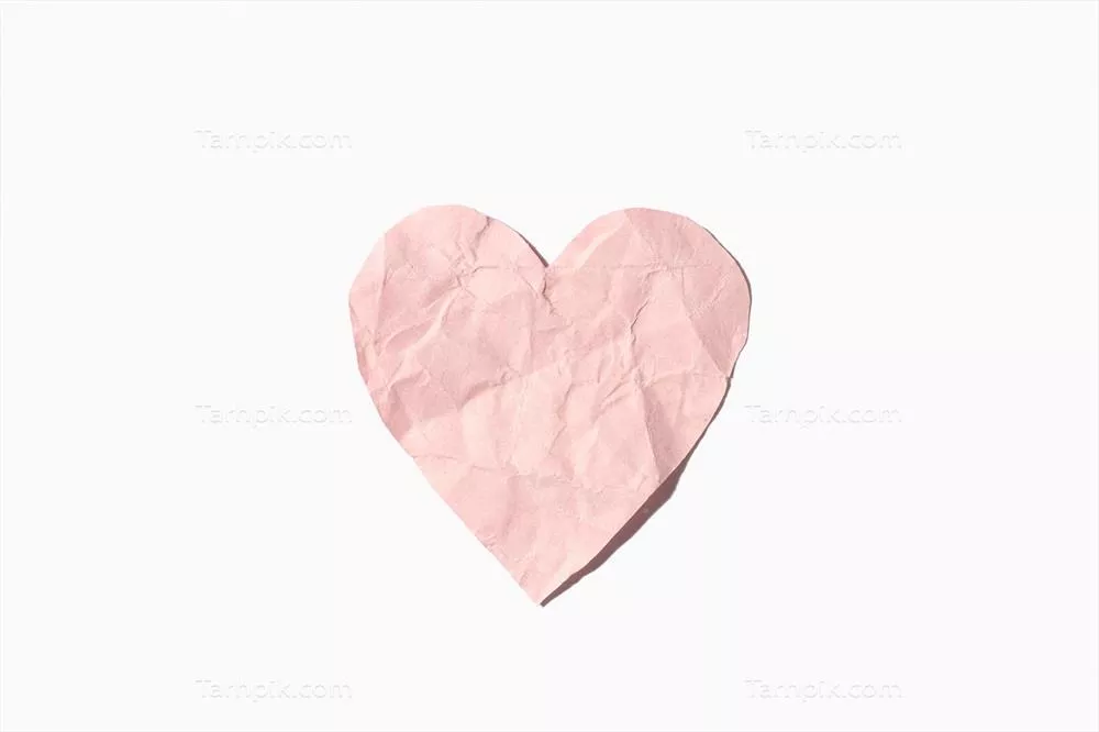 قلب کاغذی مچاله شده صورتی جدا شده روی پسزمینه سفید