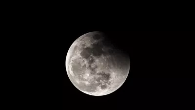 تصویر ماه در شب تاریک با زمینهای تاریک و رازآلود