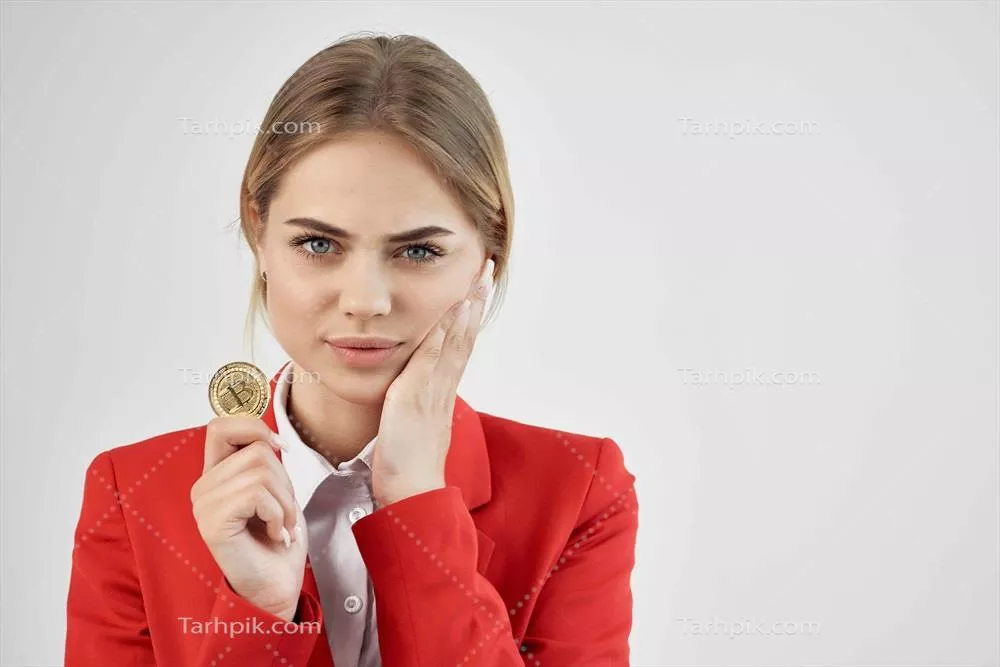 زن کسب و کار در کت قرمز با سکه طلا و بیت کوین در پس زمینه روشن