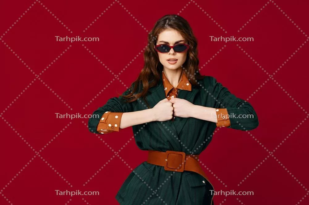 زنی مد روز در Suit با عینک آفتابی در پس‌زمینه قرمز لوکس