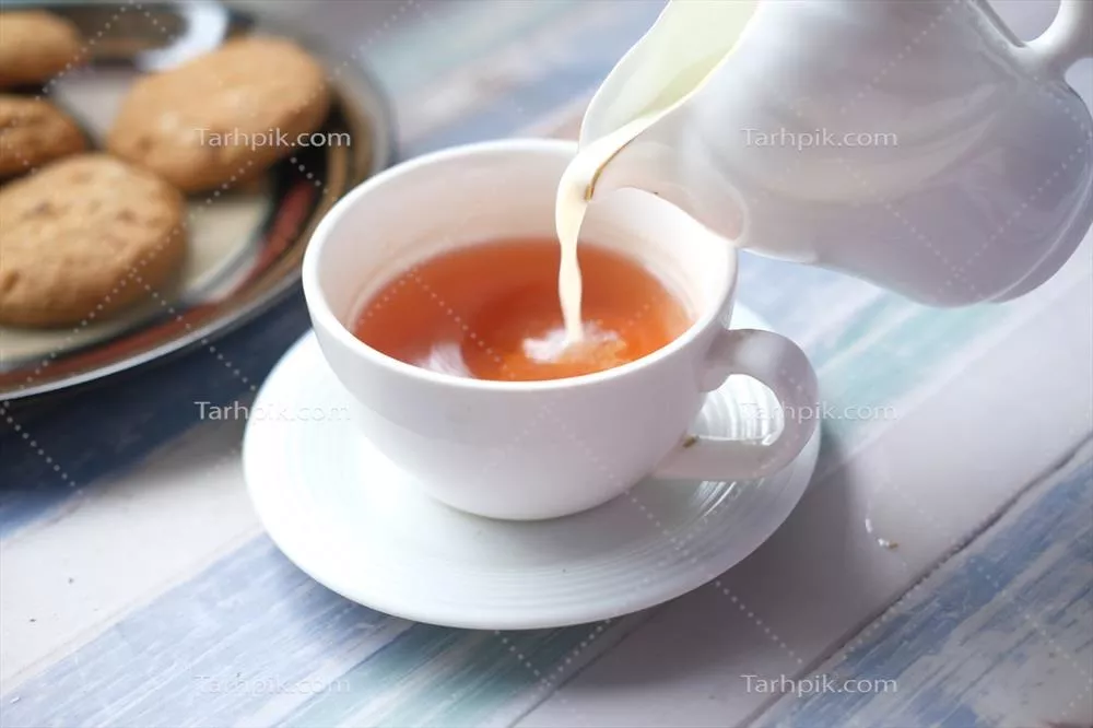 تصویری نزدیک از ریختن شیر در فنجان چای
