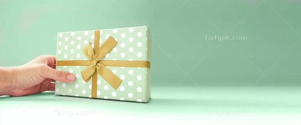 هدیه سبز زیبا در دست انسان بر روی پسزمینه سبز عمیق برای روز پدر، مادر، کریسمس و تولد