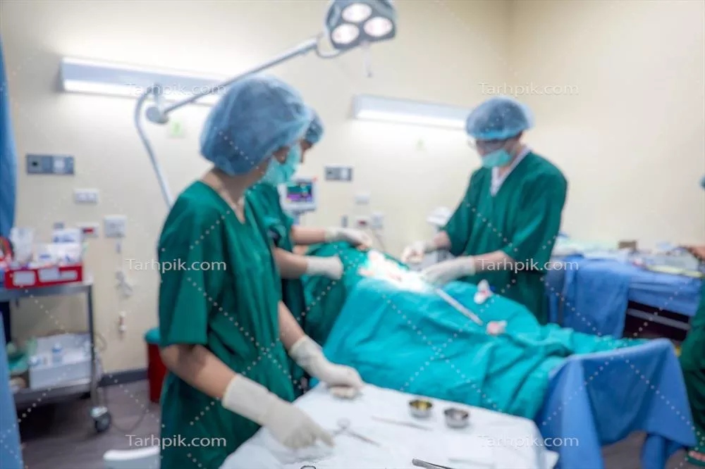 پسزمینهای تار از اتاق عمل مدرن در بیمارستان با گروهی از جراحان و تجهیزات جراحی