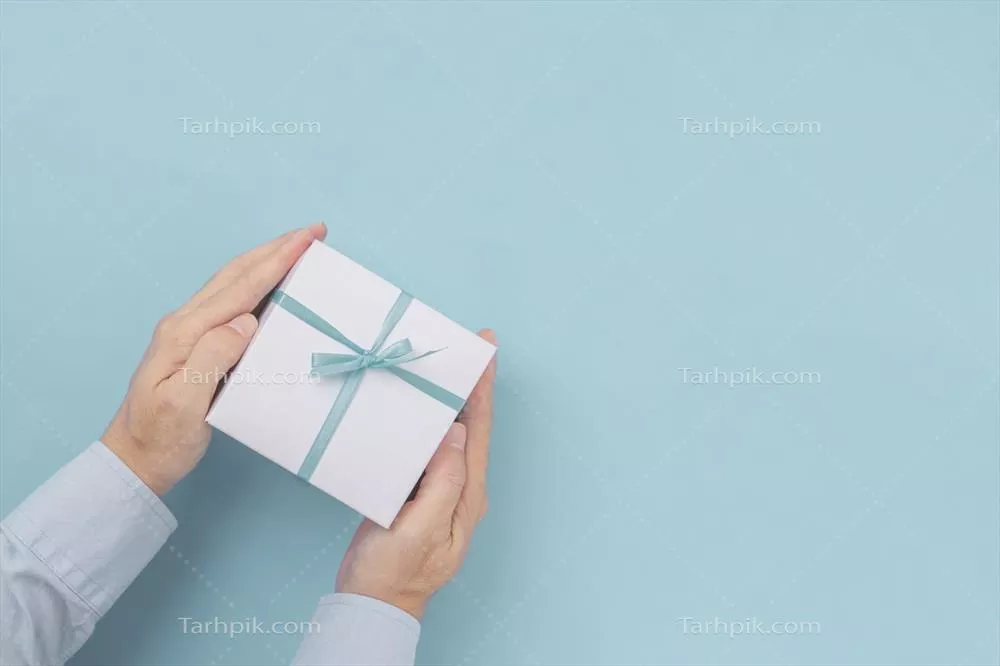 نگاهی به هدیهای زیبا در جعبه کادویی با روبان آبی در زمینه آبی