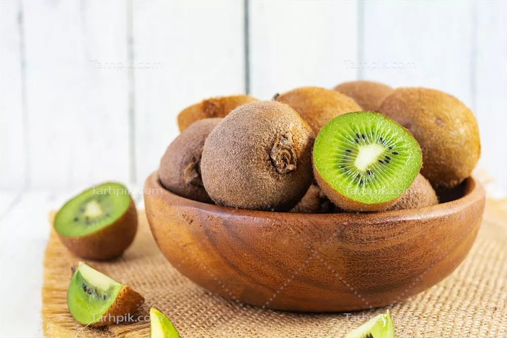 میوه کیوی تازه و آبدار، برش خورده بر روی پس زمینه سفید