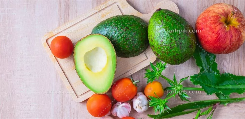 نمای بالا از میوه آووکادو تازه نصف شده و ترکیبات لازم برای آشپزی