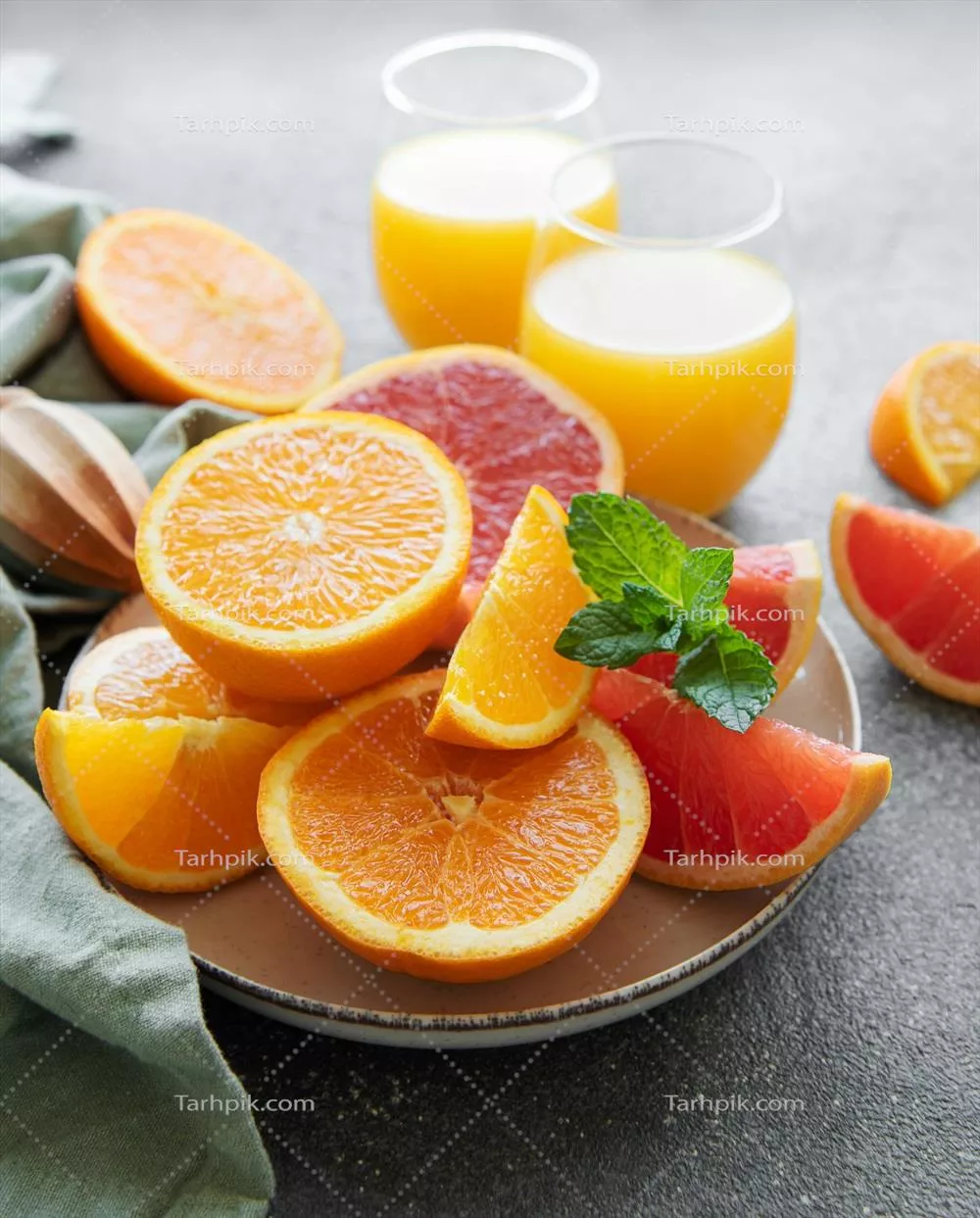 لیوانهای آبمیوه و میوههای مرکبات تازه و خوشمزه