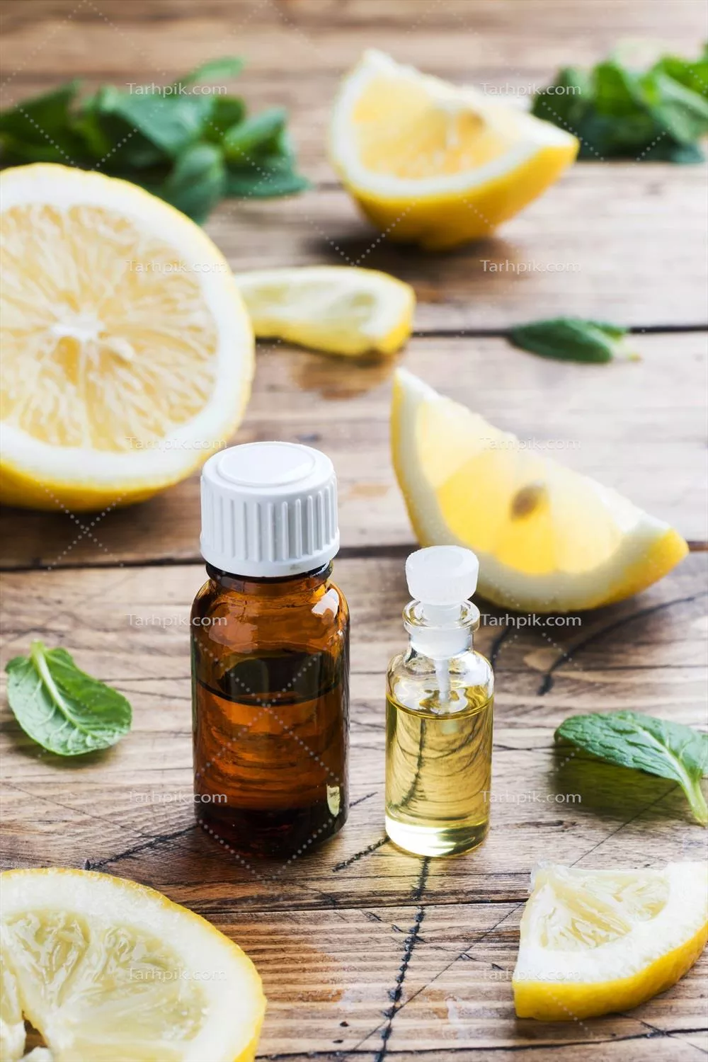 روغن لیمو ضروری در بطری با برشهای میوه تازه بر روی پسزمینه چوبی