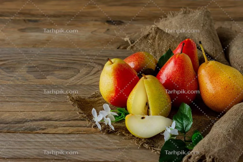 چیدن گلابی‌های رسیده و ارگانیک بر روی پارچه کنفی در فصل پاییز