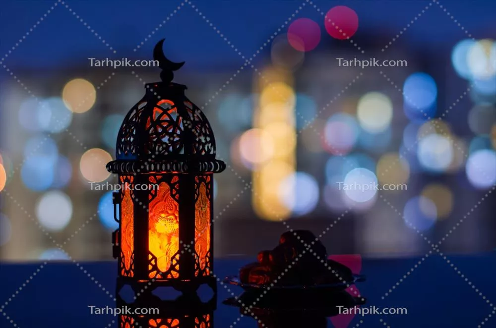 تمرها و چراغ رمضان با نمایی از ساختمان‌های آپارتمانی در پس‌زمینه