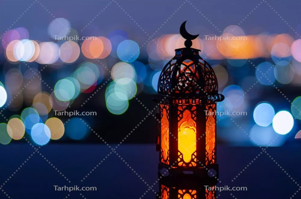 نورافشانی فانوسی با نماد ماه روی آن در شب رمضان کریم با روشنی شهری